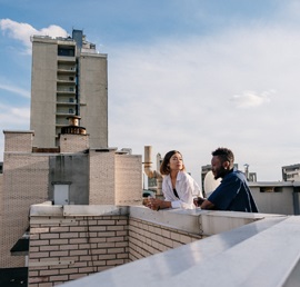 A photo of an interracial couple having a conversation at a rooftop